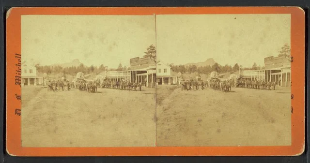 Freight wagons and teams on a Prescott street with storefronts and Thumb Butte in paired views