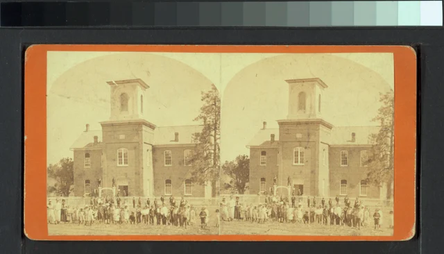 Children and adults standing outside a brick Prescott schoolhouse in paired stereoscopic photographs